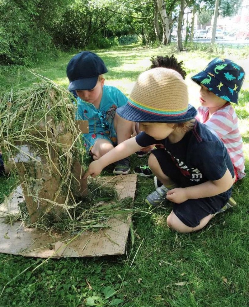 Making a house out of straw, grass and card for our ‘Three Little Pigs’!